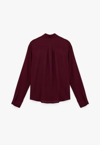 Burgundy long-sleeve shirt with a back pleat, button cuffs, and a classic collar. Smooth fabric with a flowing design.