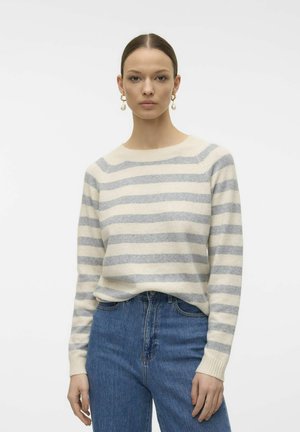 Stribet sweater i creme og lys grå uldblanding, med rund hals og ribbet manchetter. Båret med høj talje blå denim jeans.