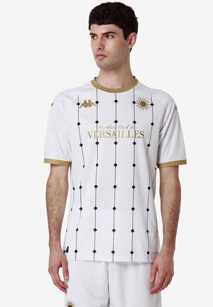 Camisa blanca de manga corta con detalles dorados, con un patrón de cuadrícula de líneas negras y diamantes; logotipo "Versailles" en dorado en la parte delantera.