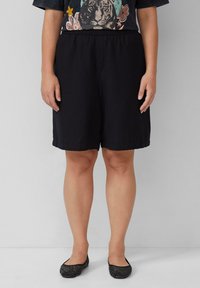 Zwarte casual shorts van zacht stof, met een elastische tailleband en een relaxed fit die tot halverwege de dijen komt.