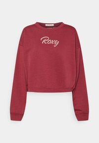 Bordeauxfärgad kort sweatshirt med långa ärmar och "Roxy" broderat i ljusrosa bokstäver över bröstet.