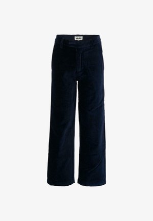 Pantalons en velours bleu marine avec une coupe évasée, dotés de passants de ceinture, d'une fermeture éclair à l'avant et d'une texture lisse. Étiquette de logo visible à l'intérieur de la taille.