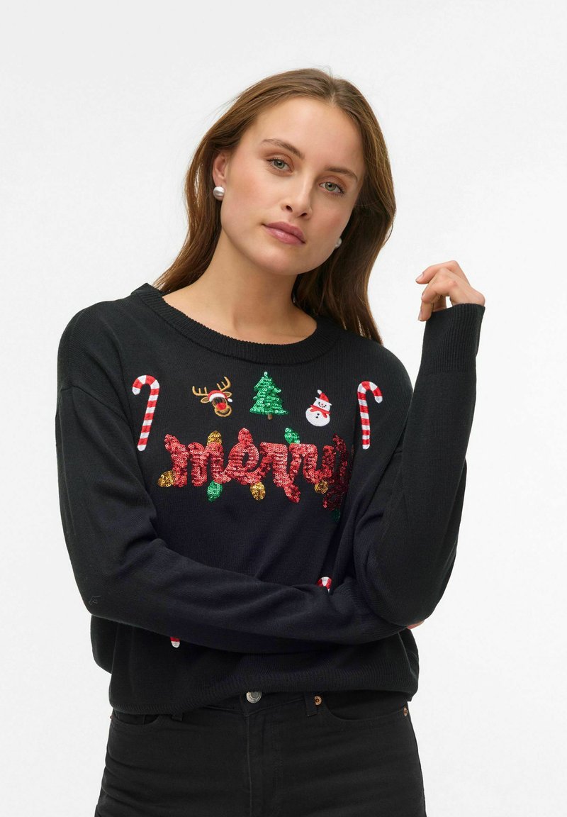 Juodas megztinis su šventiniais papuošimais: siūtu žodžiu „Merry“, saldainių lazdelių, elnio, eglutės ir sniego senio piešiniais. Ilgos rankovės.