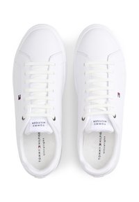 Άσπρα αθλητικά παπούτσια με επίπεδα κορδόνια, λείο συνθετικό υλικό, στρογγυλή μύτη και διακριτικό λογότυπο στο πλάι και στη γλώσσα.