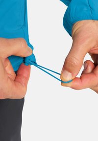 Giacca impermeabile blu con cordoncino elastico ai polsini, regolata da due mani. Caratterizzata da una texture liscia e una vestibilità regolabile.
