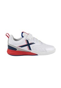 Zapatilla deportiva blanca con acentos azules y rojos, que cuenta con una correa de Velcro, parte superior texturizada y suela de goma con un diseño distintivo.