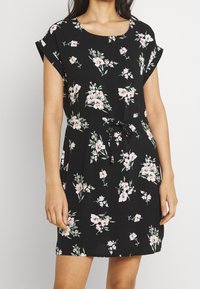 Zwarte bloemenjurk met een ronde halslijn, korte mouwen en een verstelbare strik taille. De stof heeft een zachte textuur met roze en groene patronen.