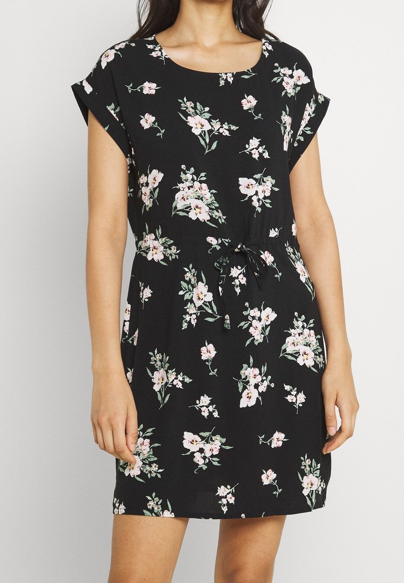 Zwarte bloemenjurk met een ronde halslijn, korte mouwen en een verstelbare strik taille. De stof heeft een zachte textuur met roze en groene patronen.