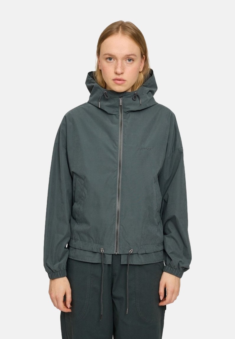 Dark green hooded jacket with a zip front, elastic cuffs, adjustable drawstring hem, and minimalistic design featuring subtle branding.