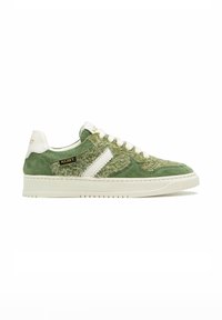 Sneaker en velours vert avec un dessus en tissu texturé, accents blancs, bout rond, semelle plate blanche et détails en logo doré sur le côté.