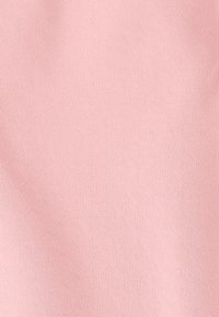 Tissu texturé rose clair avec un motif diagonal subtil, présentant une surface lisse et une sensation douce et extensible. Convient pour les vêtements ou les textiles.