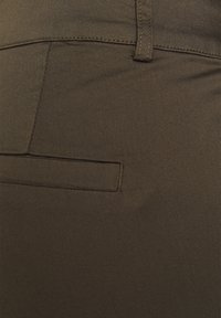 Pantaloni verde oliva realizzati in morbido tessuto elasticizzato, con una vestibilità slim, tasca anteriore piatta e dettagli di cucitura discreti.