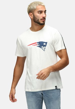Witte T-shirt met een blauw en rood logo van de New England Patriots. Korte mouwen met een rechte zoom en een klein zwart label aan de onderkant.