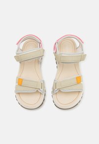 Beige sandaler med grå stropper og oransje detaljer. Justerbare Borrelås-lukkinger og teksturerte såler, med en glatt fotseng.