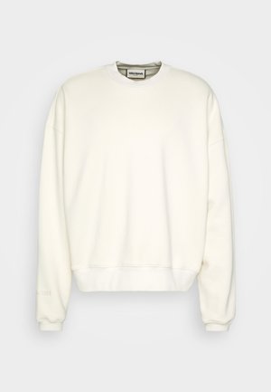 Jednoduchá krémově bílá mikina s kulatým výstřihem, dlouhými rukávy, pružnými manžetami a lemem a malou značkovou cedulkou uvnitř výstřihu.