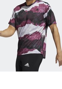 Kortärmad sporttröja med ett bergetsmönster i lila, vitt och svart. Tillverkad av lätt, ventilerande tyg.
