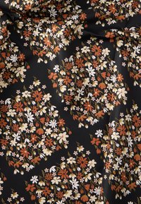 Tecido floral preto com pequenas flores brancas, laranja e creme, apresentando uma textura suave e brilhante e padrões intrincados de flores por todo o tecido.