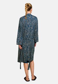 Floral-patterned robe in dark blue with long sleeves, waist tie, and ankle length. Features a shawl collar and soft fabric texture.