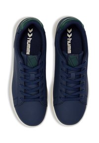 Marinblå sneakers med en slät läderöverkant, texturerad tygfoder och kontrasterande grön häl. Inkluderar rund snörning och logotypdetaljer.