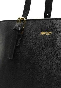 Sort tote taske med en tekstureret overflade, med et gyldent logo, en glat rem med en spænde og et rent, minimalistisk design.