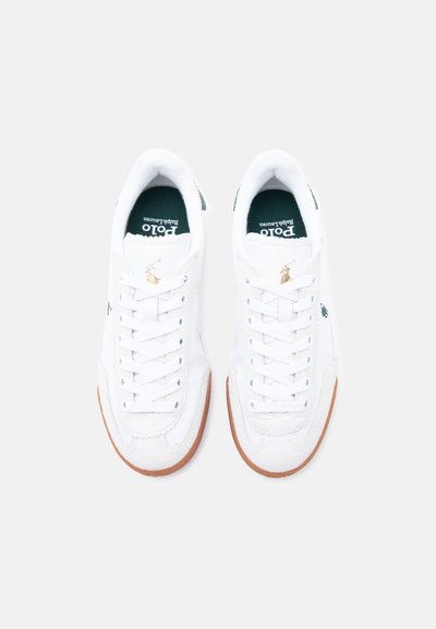 Pár fehér Polo Ralph Lauren sportcipő barna talpakkal, fehér fűzőkkel és zöld logóval az oldalán, felülnézetből, világos háttéren.