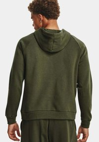 Felpa verde con cappuccio regolabile, polsini e orlo a coste. Tessuto morbido, vestibilità regolare e maniche raglan per una maggiore libertà di movimento.