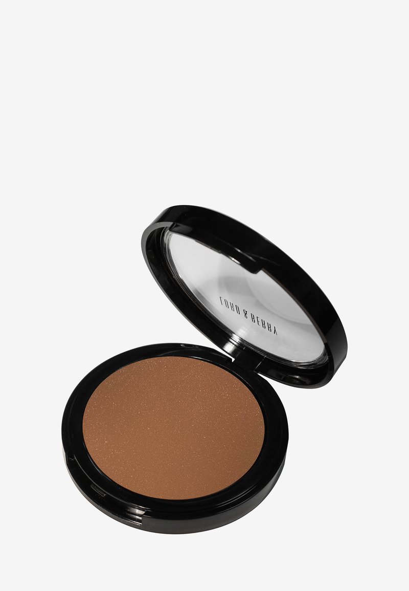 Bronzer in una confezione tonda e compatta. Polvere marrone liscia e opaca con una leggera lucentezza. Est exterior in plastica nera con coperchio trasparente.