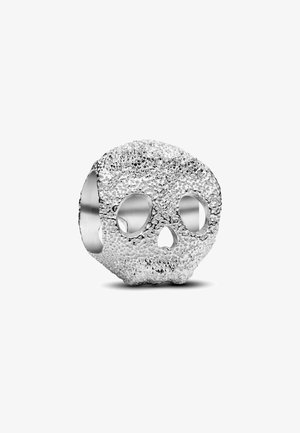 Anello a forma di teschio in argento con una texture, con occhi e naso vuoti, su sfondo bianco.