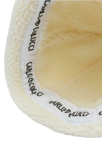 Cream-colored fleece bucket hat with a soft texture and a logoed inner band featuring "CARLO COLUCCI" in black lettering.