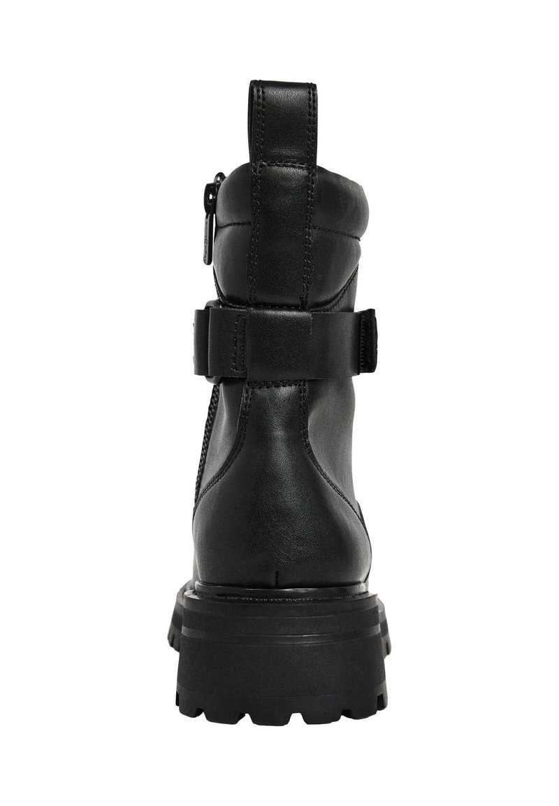 Bota de tobillo de cuero negro con punta redondeada, cremallera lateral, correa ajustable y suela gruesa y resistente. Cuenta con un tirador en el talón reforzado.
