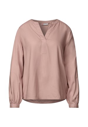 Blouse rose pâle, décolleté en V, manches longues bouffantes, tissu lisse, coupe ample et léger éclat.