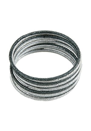Ensemble d'élastiques à cheveux recouverts de tissu noir et argent empilés en alternance sur un fond blanc.