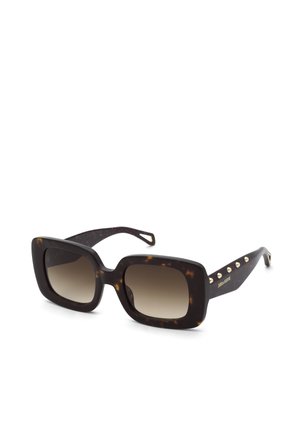 Lunettes de soleil carrées surdimensionnées en écaille foncée avec des verres marron dégradés et des détails de clous dorés sur les branches.
