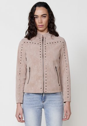 Tan faux leather jacket featuring a stand-up collar, studded accents along the front, and zippered side pockets. Textured surface.