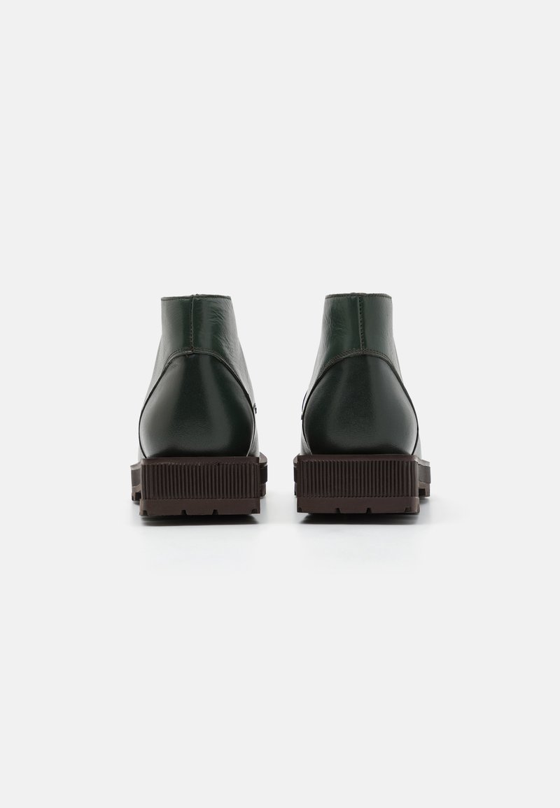 Grüne Leder-Ankle-Boots mit matter Oberfläche, abgerundeter Spitze und texturiertem braunem Gummiaußensohle. Minimale Nähte und keine sichtbaren Beschläge.