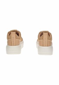 Un paio di sneaker in pelle marrone chiaro con suole bianche spesse, viste dal retro, con linguette sul tallone cucite e impresse con la scritta "SMITH".