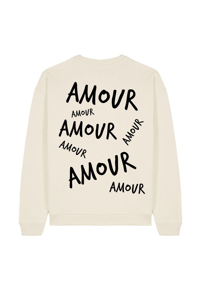 Creme-kleurige sweatshirt met opvallende zwarte tekst die "AMOUR" spelt in verschillende groottes en oriëntaties op de achterkant. Ronde halslijn en geribde boorden.