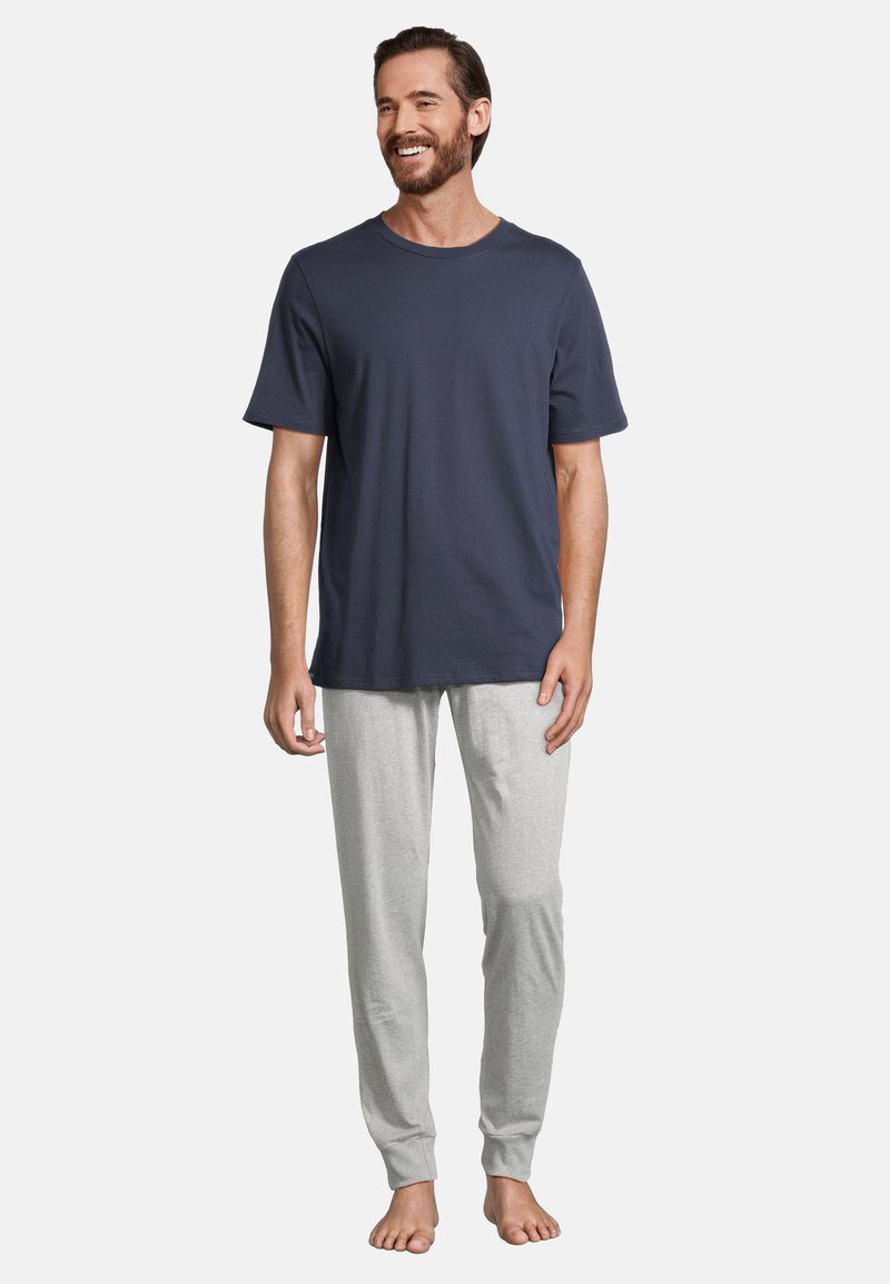 T-shirt bleu marine à col rond associé à un pantalon de pyjama léger et fuselé. Les deux sont en coton doux.