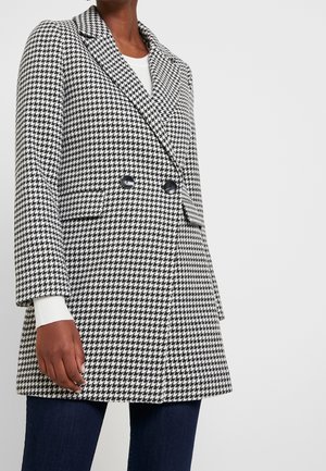 Houndstooth-patroon blazer in zwart en wit, met een dubbelzijdig ontwerp, gesneden revers en twee voorzakken.