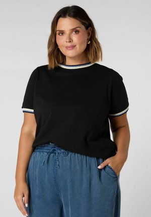 Zwarte t-shirt met korte mouwen en een ronde halslijn, afgewerkt met blauwe en crèmekleurige details, gecombineerd met casual blauwe broek met een elastische tailleband.