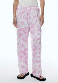 Roze bloemenpyjama broek van een lichte, zachte stof. Voorzien van een elastische tailleband met een trekkoord en een relaxte pasvorm.