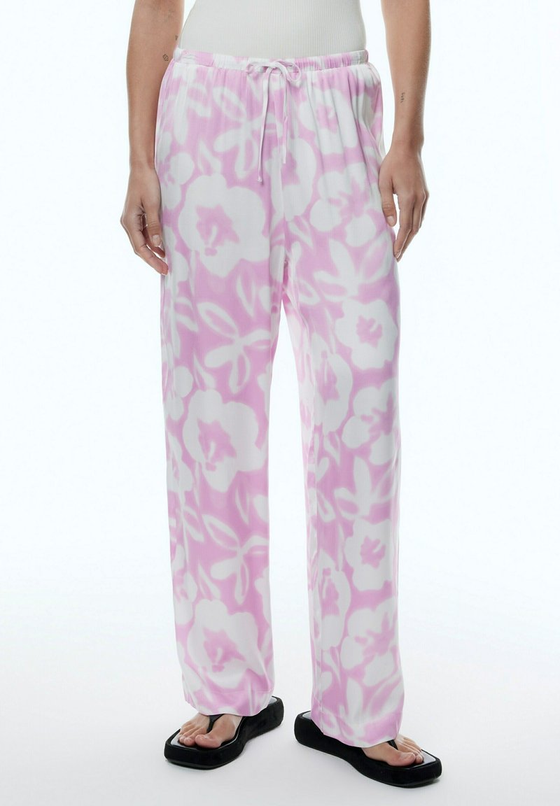 Roze bloemenpyjama broek van een lichte, zachte stof. Voorzien van een elastische tailleband met een trekkoord en een relaxte pasvorm.