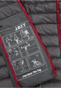 Grijze gewatteerde jas met een interieur met rode afwerking, voorzien van gedrukt grafisch materiaal dat verschillende activiteiten in de buitenlucht afbeeldt en de tekst "J.O.T.T Just Over The Top".