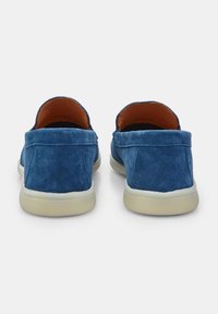 Blaue Wildleder-Slipper mit niedrigem Profil und cremefarbenen Gummisohlen, die eine glatte Textur und minimalistische Nähte aufweisen.