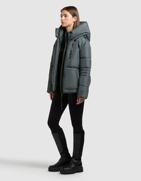 Polstret hættejakke i grå, med lynlåslommer, elastiske manchetter og en afslappet pasform, kombineret med sorte leggings og knæhøje støvler.