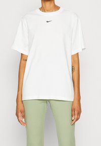 Vit bomullst-shirt med rund halsringning och korta ärmar. Har en liten svart Nike-logotyp på bröstet.