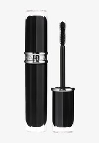Tube de mascara noir avec une base transparente, présentant des rainures verticales et une bande chromée. Une brosse noire à nervures est incluse.