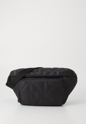 Borsa a spalla nera trapuntata con tasca frontale con zip, tracolla regolabile e motivo geometrico cucito nel tessuto.