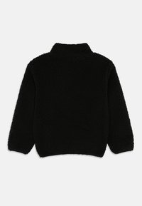 Giacca in pile nera con maniche lunghe e colletto alto, vista da dietro su uno sfondo bianco.