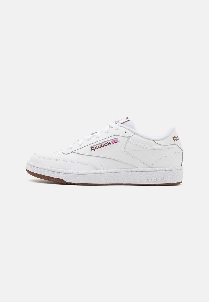Bijele Reebok tenisice sa glatkom teksturom, s gumenom potplatom, vezanjem sprijeda i logotipom na stranama i na jeziku.